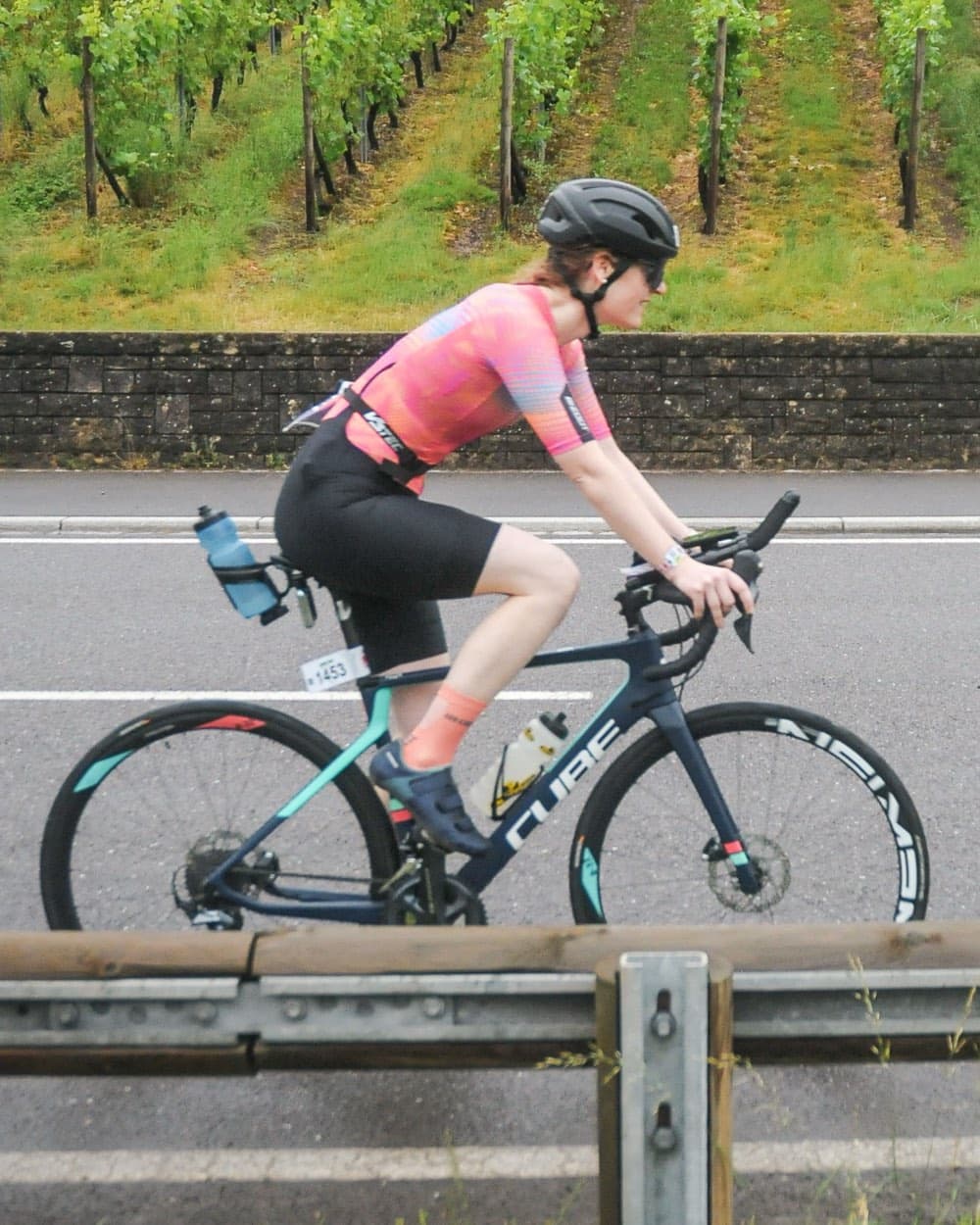 Lisa Engel beim Radrennen auf dem Rennrad vor Weinbergen