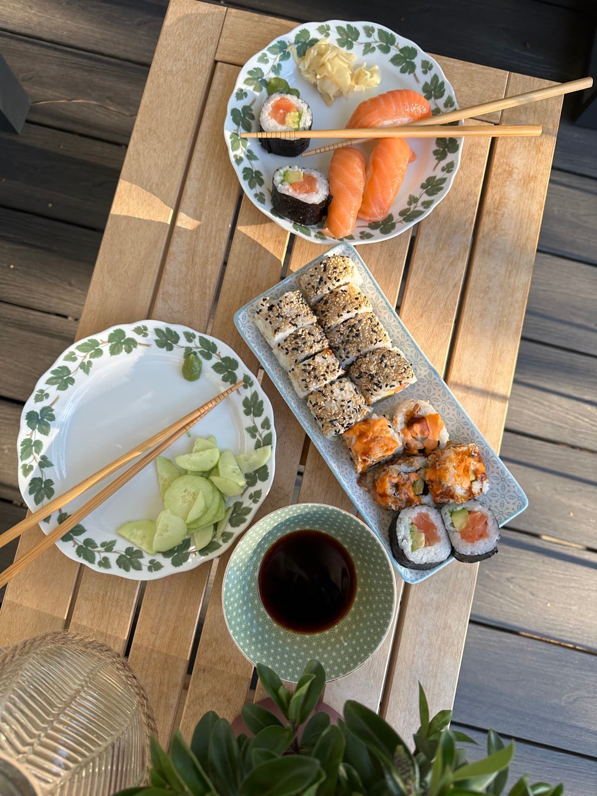 Gedeckter Esstisch mit Sushi-Platten, Gurken und Sojasauce